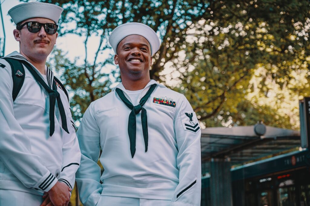 Two sailors standing next to one another.