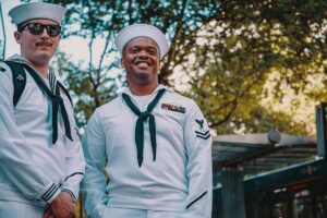 Two sailors standing next to one another.