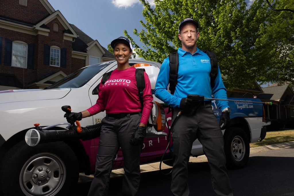Pest Authority technician in a blue polo, Mosquito Authority tech in a long-sleeved pink shirt.